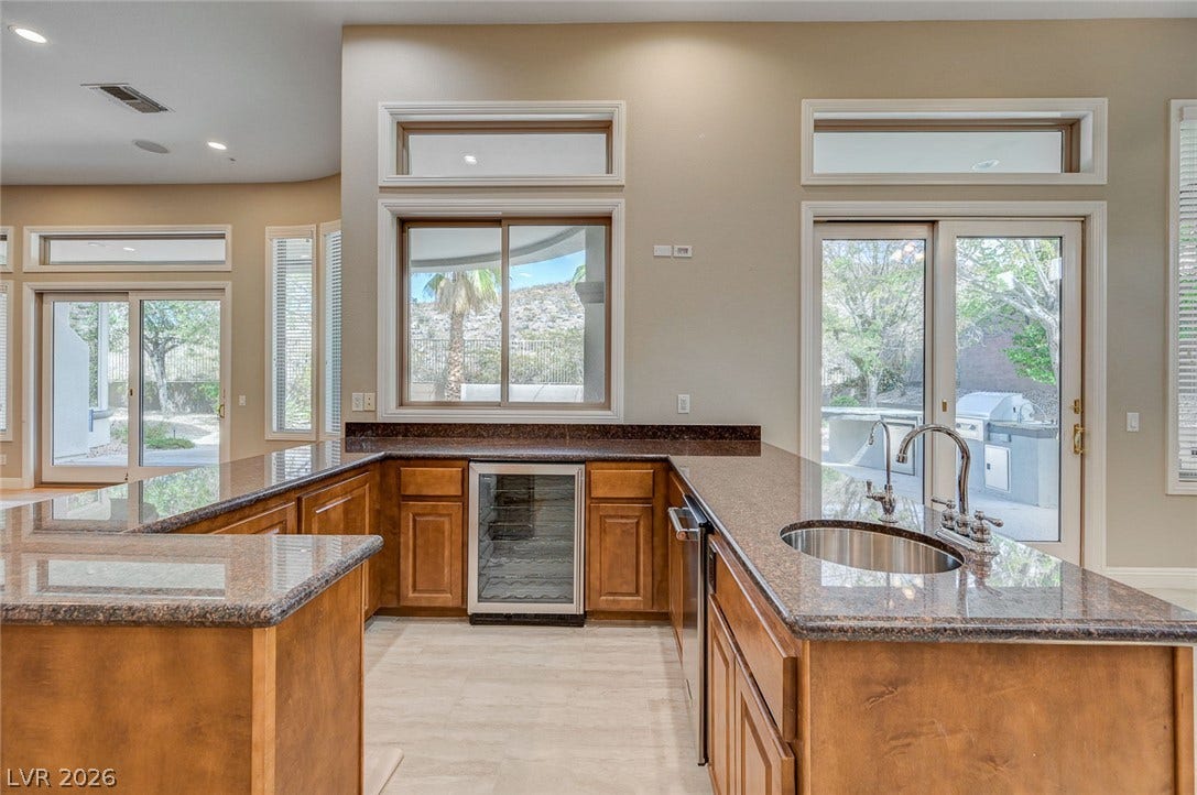 8 Starbrook Drive, Henderson, NV 89052 Gleaming stone countertops and rich wood cabinetry define this functional wet bar area.