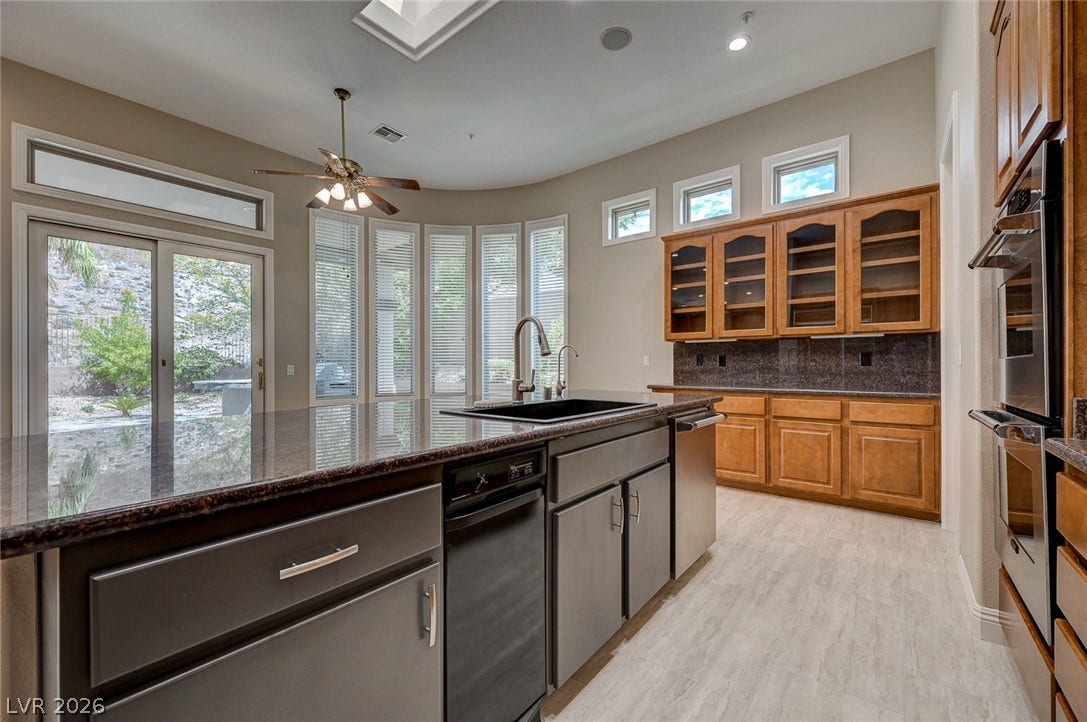 8 Starbrook Drive, Henderson, NV 89052 Granite counters and wood cabinetry anchor this spacious culinary space illuminated by a skylight.