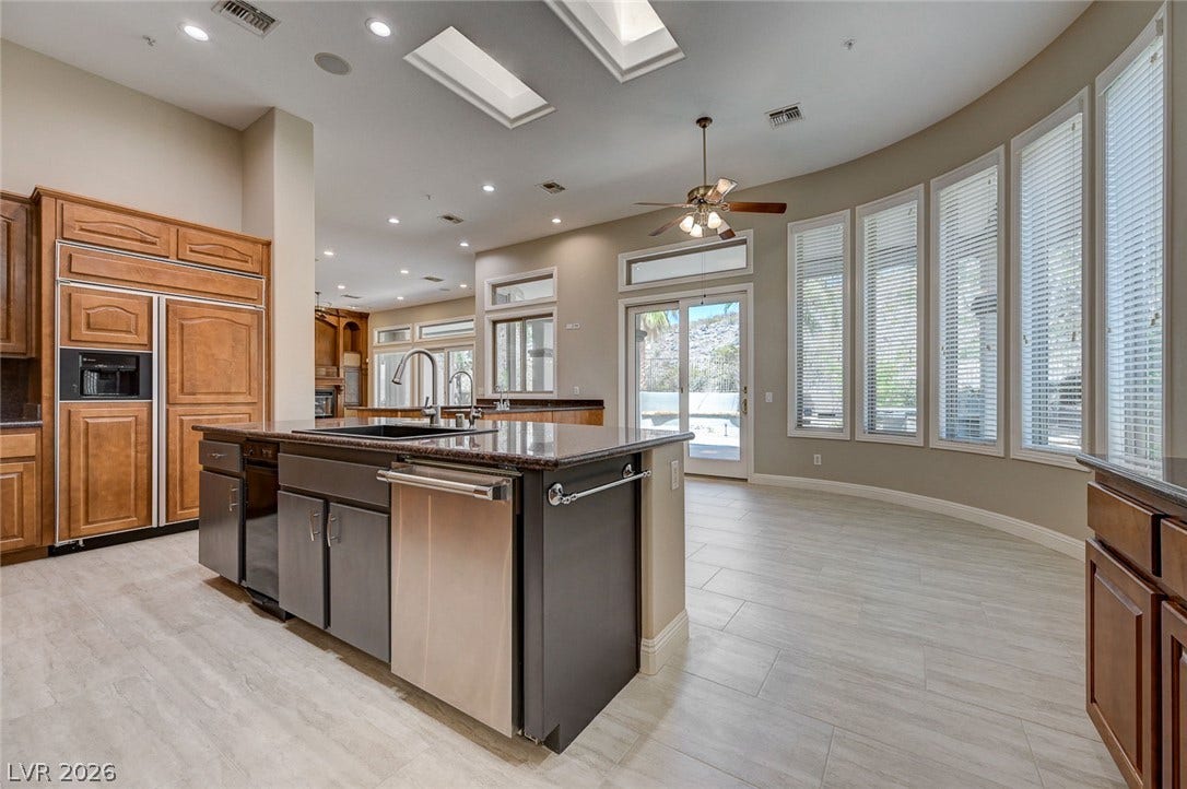 8 Starbrook Drive, Henderson, NV 89052 Soaring ceilings, skylights, and a curved wall of windows highlight this open kitchen.