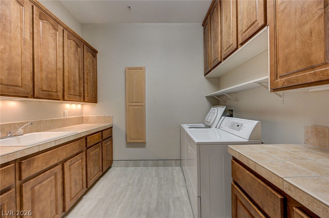8 Starbrook Drive, Henderson, NV 89052 Ample cabinetry and tile countertops flank this functional utility space with laundry appliances.