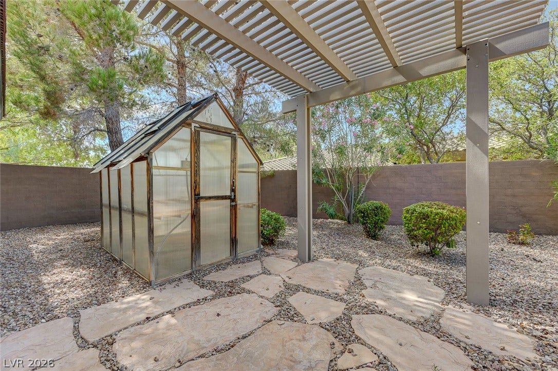 8 Starbrook Drive, Henderson, NV 89052 Flagstone paving and a wooden pergola define this peaceful backyard garden setting.