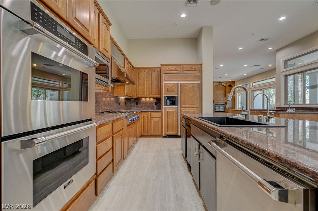 8 Starbrook Drive, Henderson, NV 89052 Ample wooden cabinetry and sleek stone countertops define this functional kitchen space.