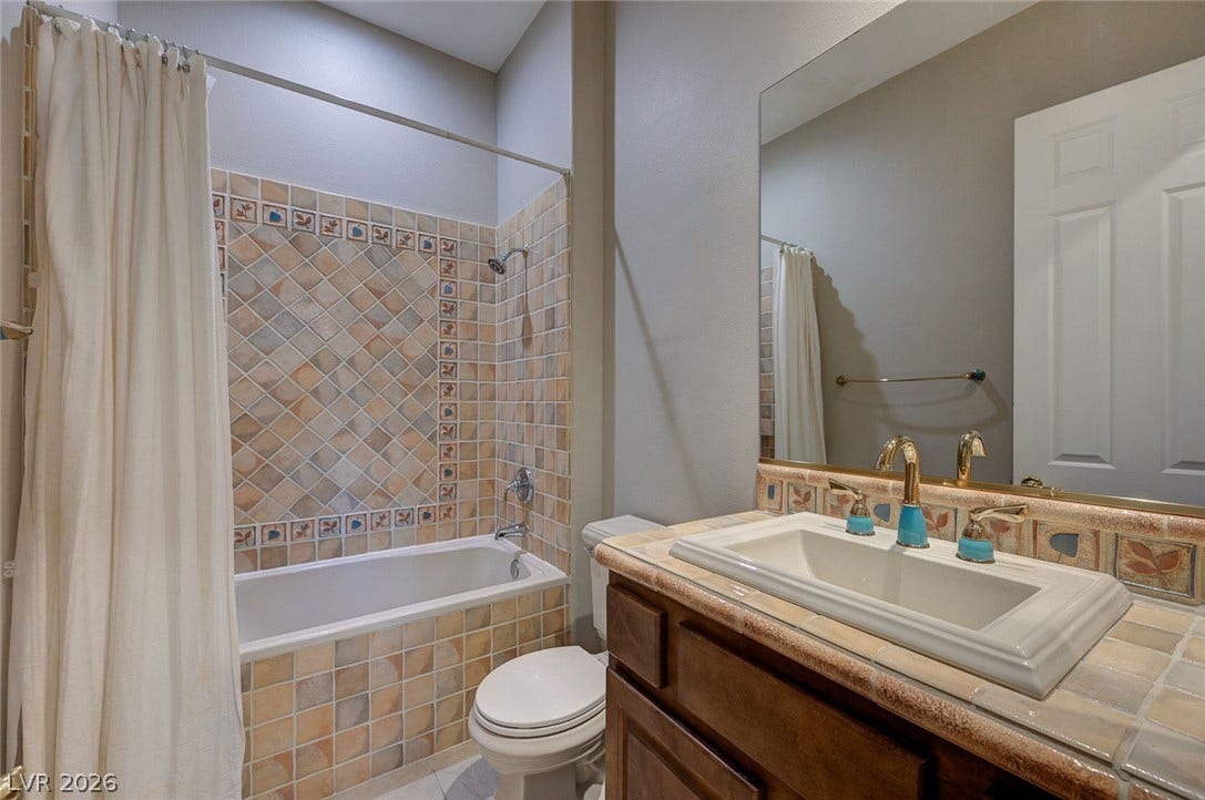 8 Starbrook Drive, Henderson, NV 89052 Tiled accents and a built-in vanity highlight this full bathroom.