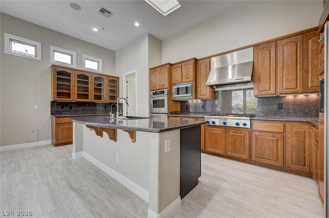 8 Starbrook Drive, Henderson, NV 89052 Rich wood cabinetry and a central stone island define this well-appointed culinary space.