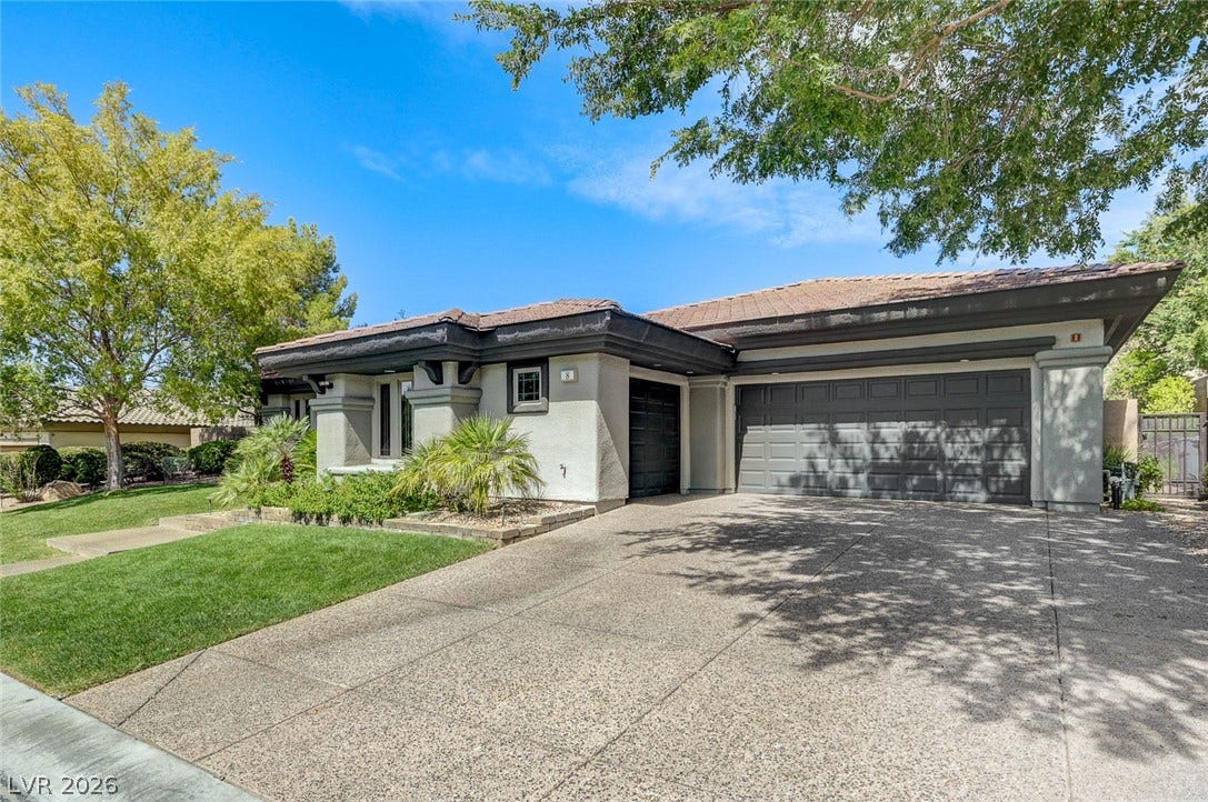 8 Starbrook Drive, Henderson, NV 89052 Mature trees shade a spacious concrete driveway leading to this classic tile-roofed residence.