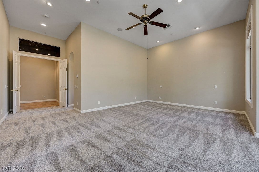 8 Starbrook Drive, Henderson, NV 89052 Double doors open into a carpeted room featuring high ceilings and recessed lighting.