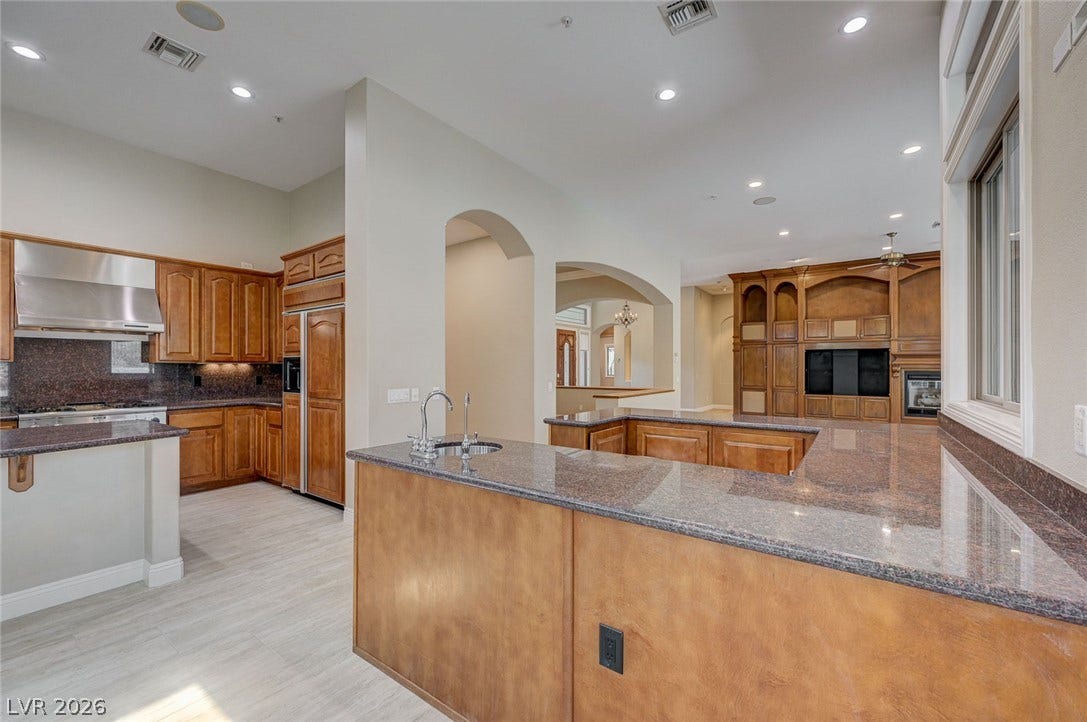 8 Starbrook Drive, Henderson, NV 89052 Gleaming stone countertops and warm wood cabinetry anchor this spacious culinary space.