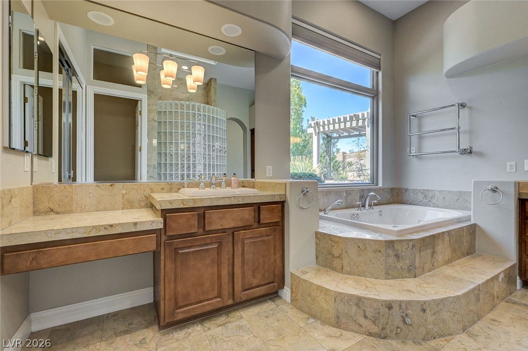 8 Starbrook Drive, Henderson, NV 89052 Natural stone surfaces and a raised soaking tub define this elegant primary bath.