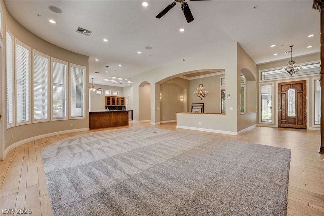8 Starbrook Drive, Henderson, NV 89052 An open floor plan connects the main living spaces across polished wood and carpeted flooring.