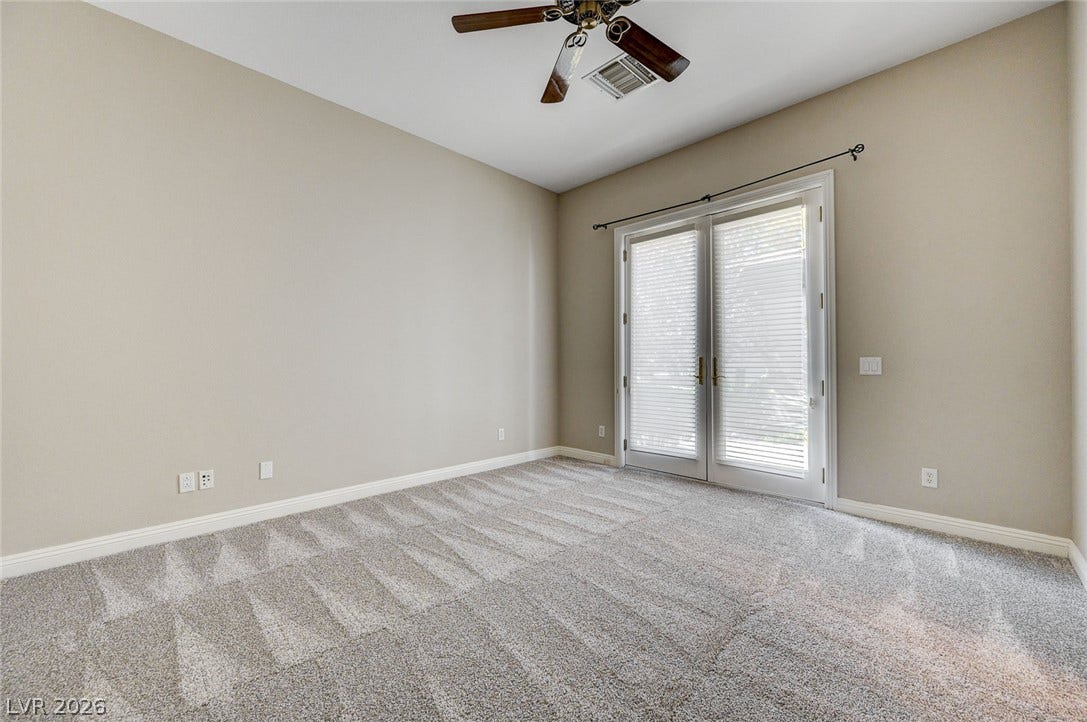 8 Starbrook Drive, Henderson, NV 89052 Double glass doors open to the outdoors in this comfortable carpeted bedroom.