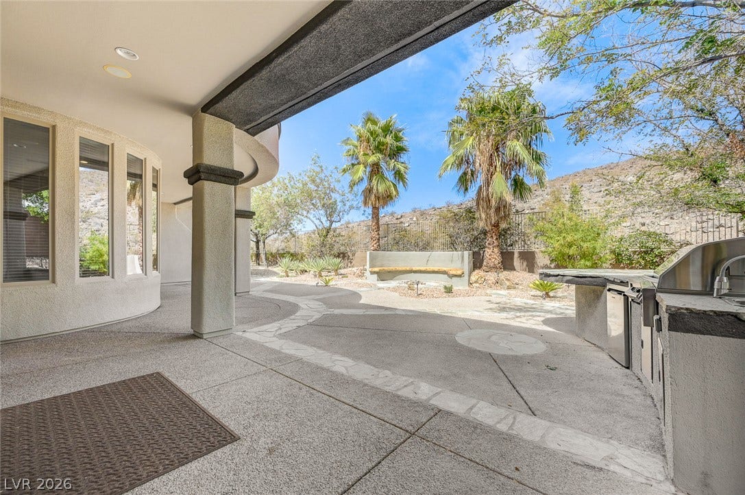 8 Starbrook Drive, Henderson, NV 89052 An outdoor kitchen highlights the spacious stone patio framed by scenic desert views.