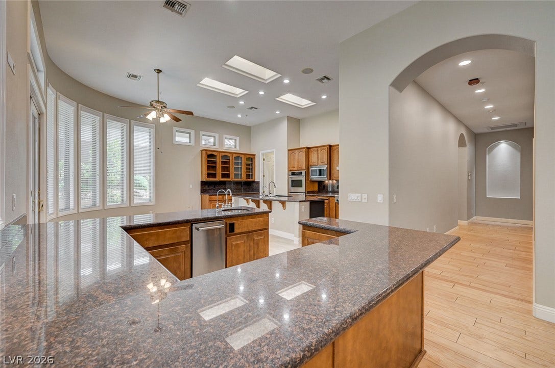 8 Starbrook Drive, Henderson, NV 89052 Granite counters and rich wood cabinetry anchor this light-filled kitchen with skylights.