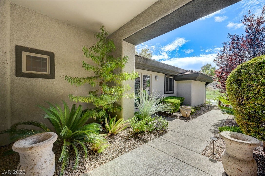 8 Starbrook Drive, Henderson, NV 89052 Lush landscaping frames a clean concrete walkway leading to the entry of this modern residence.