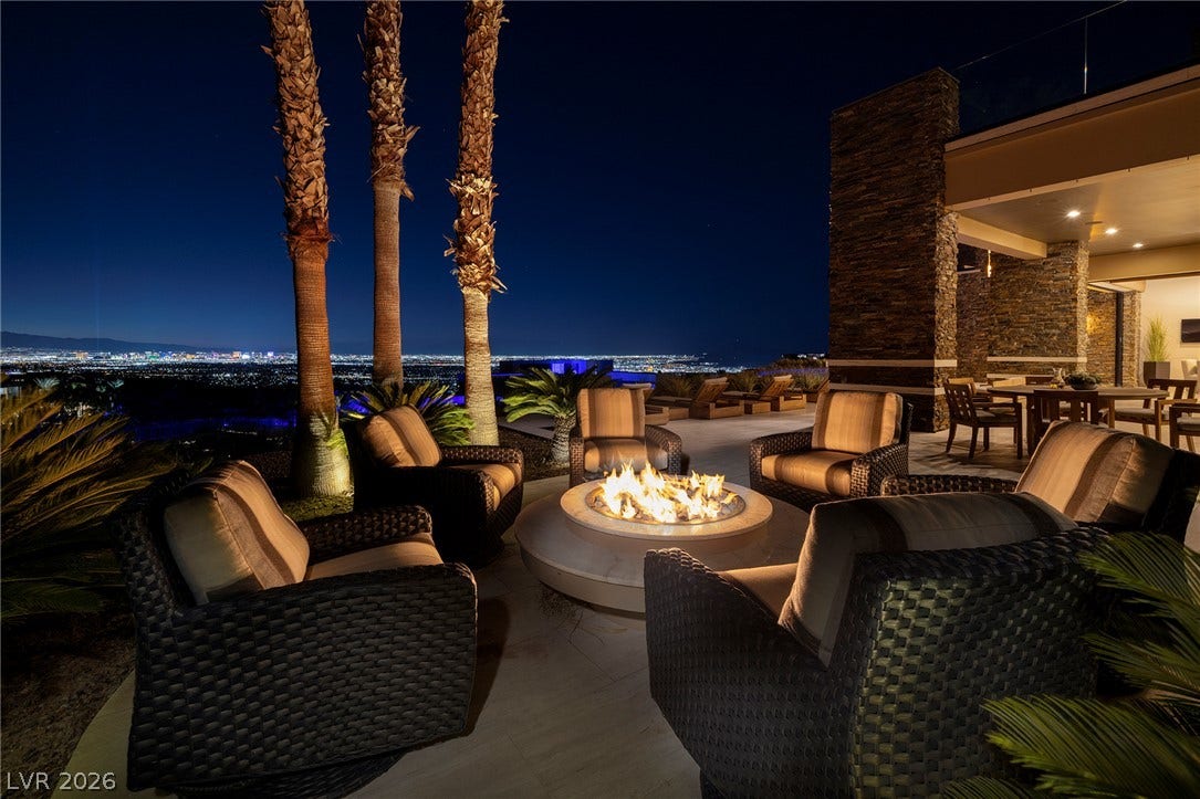 761 Dragon Ridge Drive, Henderson, NV 89012 Panoramic city lights glisten beyond a stone-accented patio complete with an integrated fire pit.