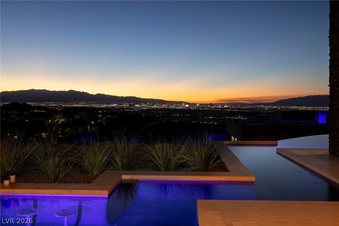 761 Dragon Ridge Drive, Henderson, NV 89012 Glistening city lights and mountain silhouettes create a dramatic backdrop beyond the modern pool.