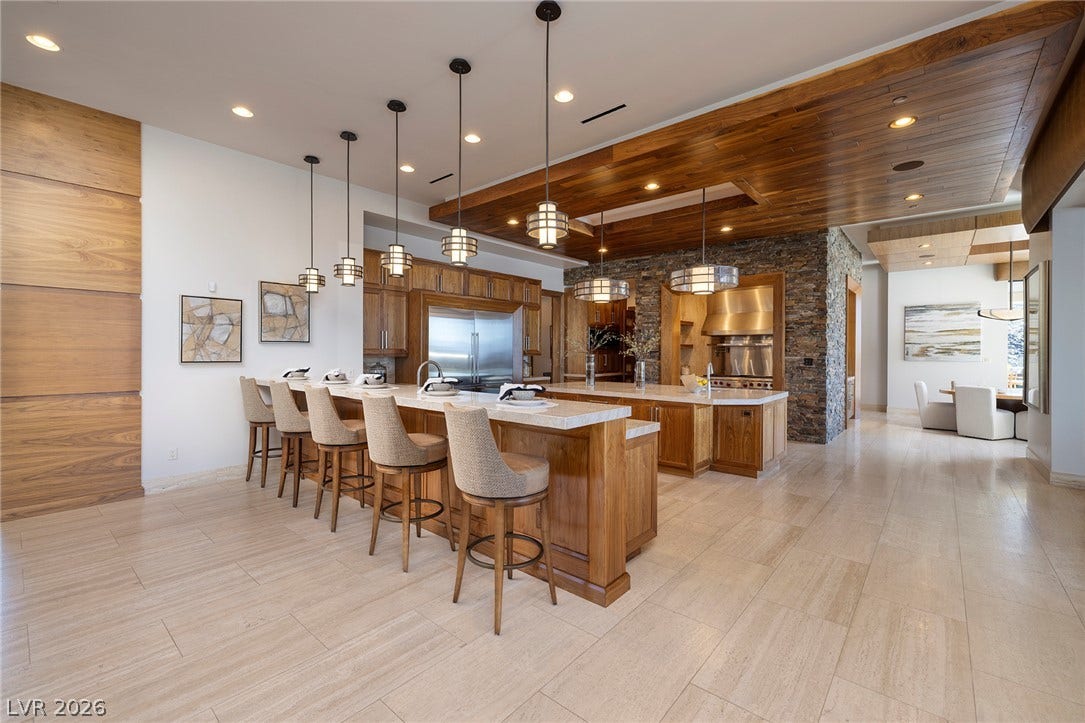 761 Dragon Ridge Drive, Henderson, NV 89012 Gleaming stone tile floors flow throughout this kitchen with custom wood paneling.