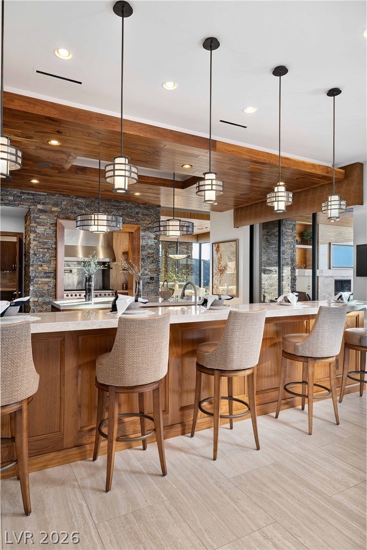 761 Dragon Ridge Drive, Henderson, NV 89012 Warm wood paneling and stone accents elevate this modern breakfast bar.
