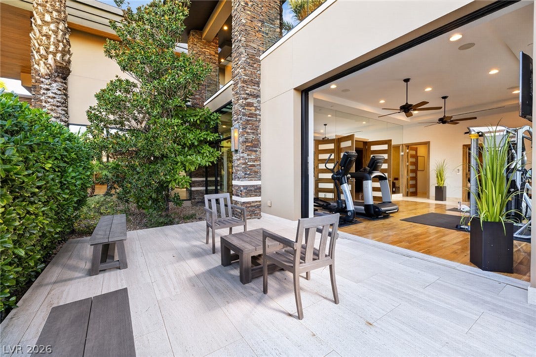 761 Dragon Ridge Drive, Henderson, NV 89012 Retractable glass doors merge a stone-accented patio with the indoor exercise room.