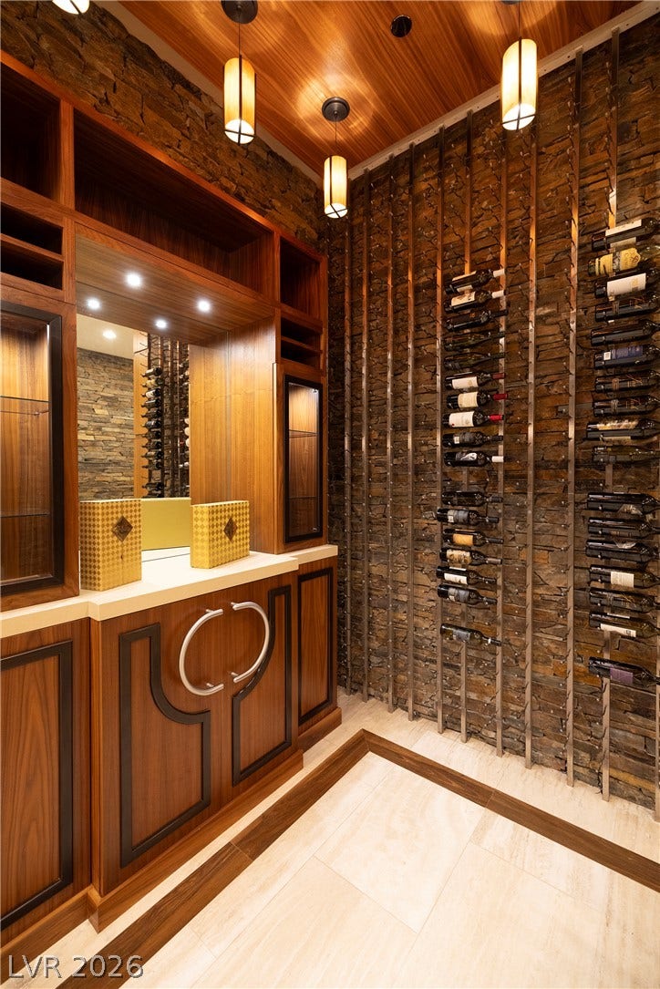 761 Dragon Ridge Drive, Henderson, NV 89012 Rich wood ceilings and custom stone walls define this elegant temperature-controlled wine cellar.