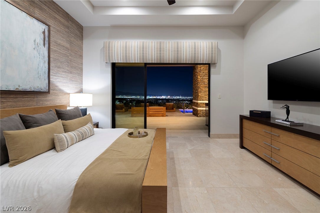 761 Dragon Ridge Drive, Henderson, NV 89012 Gleaming stone tile floors and a recessed ceiling frame twinkling night city views.