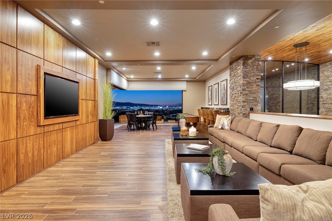 761 Dragon Ridge Drive, Henderson, NV 89012 Gleaming wood-look floors complement rich paneled walls and a stone pillar in this open living space.