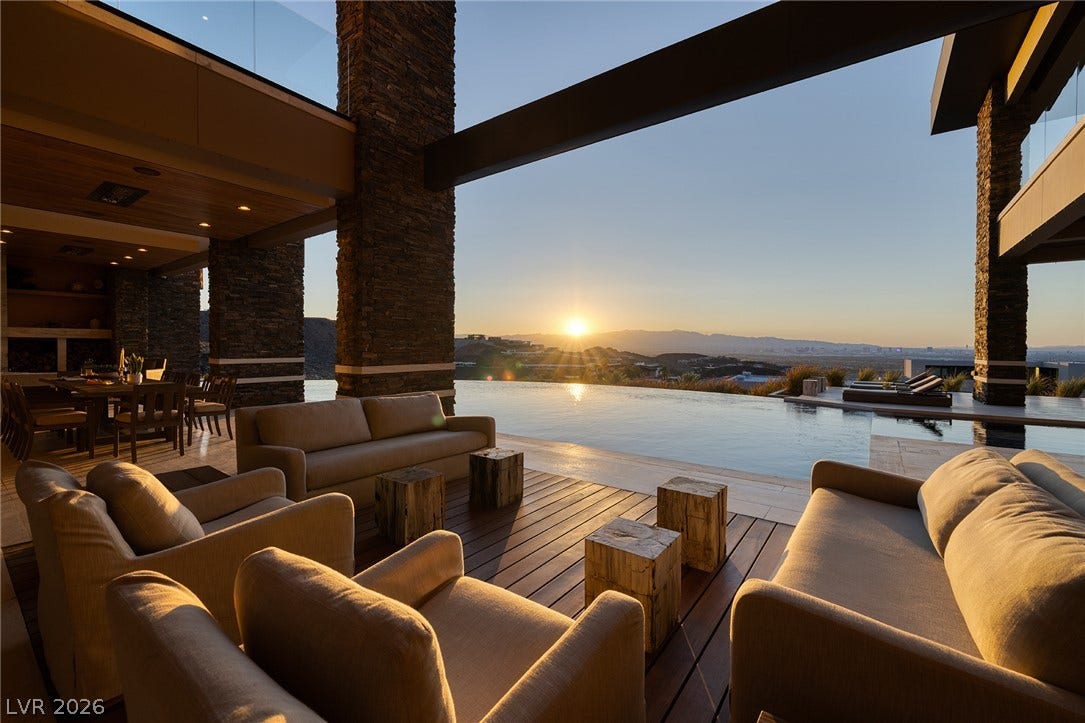 761 Dragon Ridge Drive, Henderson, NV 89012 Dramatic sunset views frame the infinity pool and expansive wood-planked outdoor terrace.