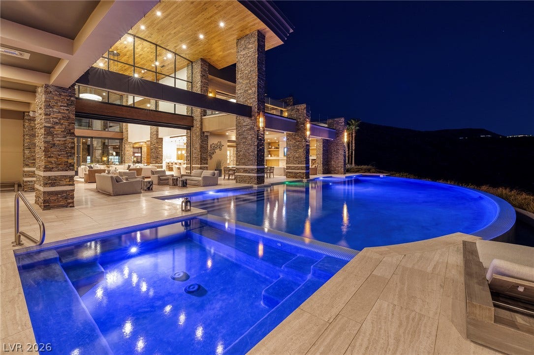 761 Dragon Ridge Drive, Henderson, NV 89012 Dramatic stone pillars flank a sparkling pool and spa set against the evening sky.