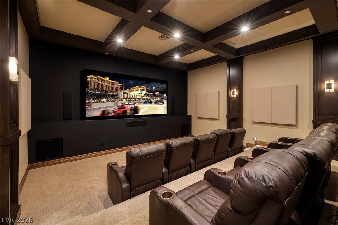 761 Dragon Ridge Drive, Henderson, NV 89012 Coffered ceilings and plush tiered flooring define this custom home theater space.