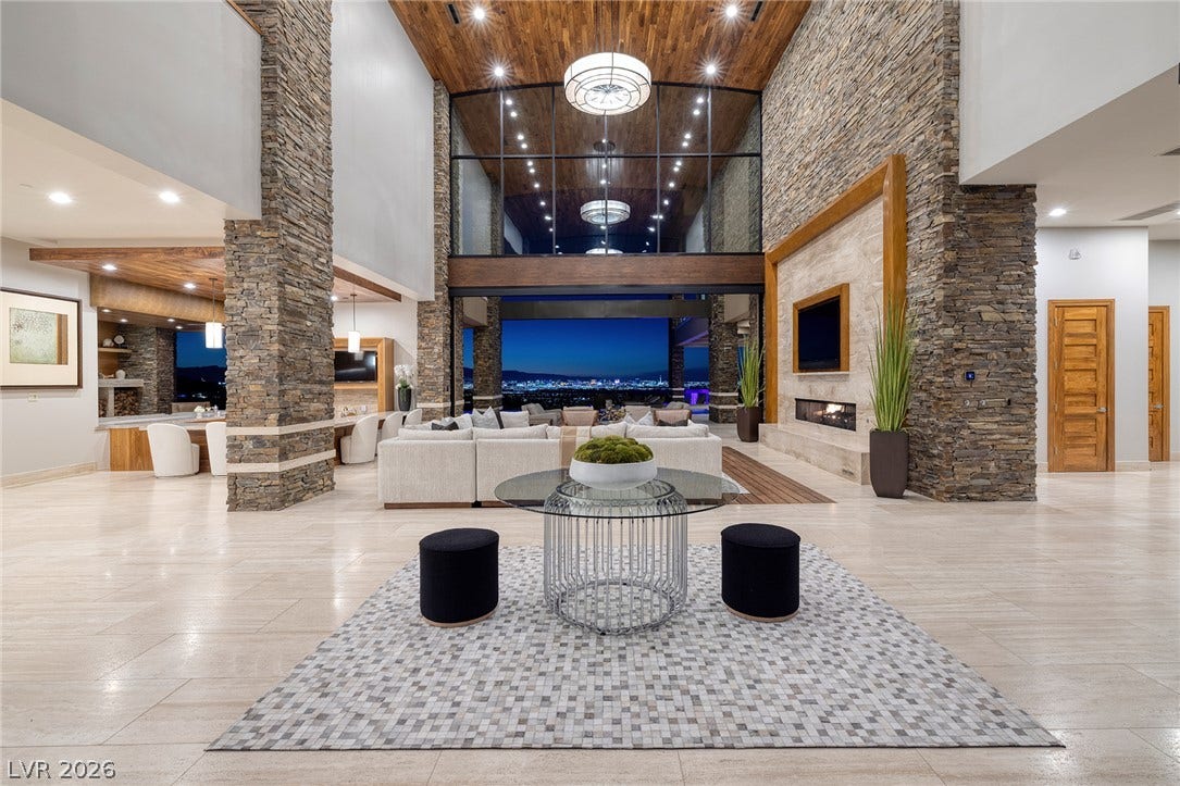 761 Dragon Ridge Drive, Henderson, NV 89012 Dramatic stone accents and towering ceilings frame far-reaching city views through soaring walls of glass.