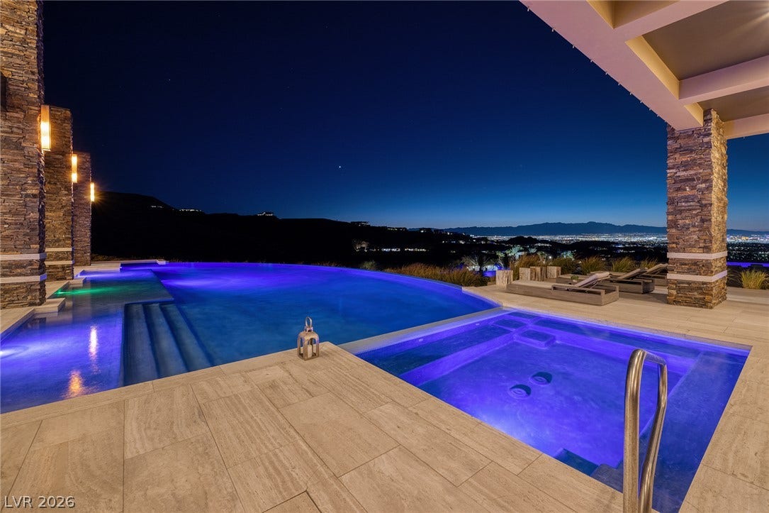 761 Dragon Ridge Drive, Henderson, NV 89012 Glistening waters and stone pillars frame a spectacular evening skyline outlook.