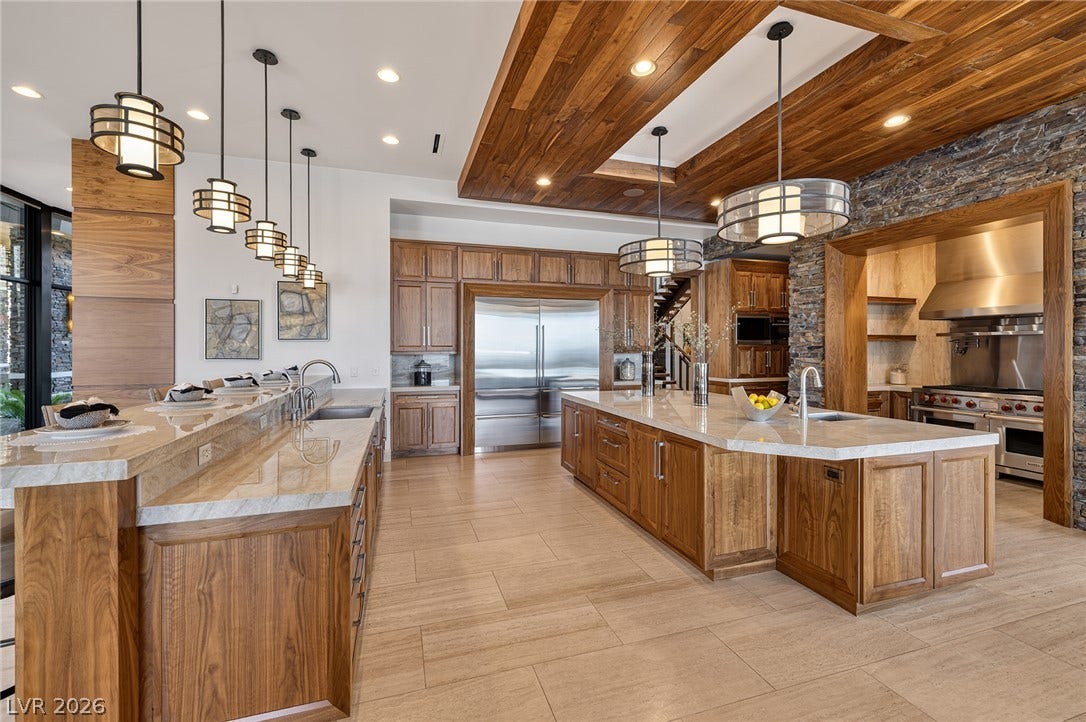761 Dragon Ridge Drive, Henderson, NV 89012 Gleaming stone countertops and custom wood cabinetry define this expansive gourmet culinary space.