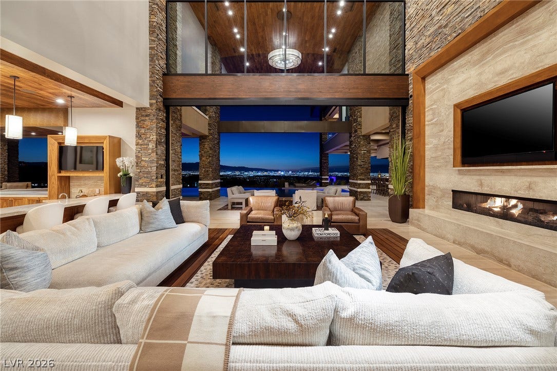 761 Dragon Ridge Drive, Henderson, NV 89012 Dramatic stone accents frame a linear fireplace and seamless indoor-outdoor living spaces with city views.