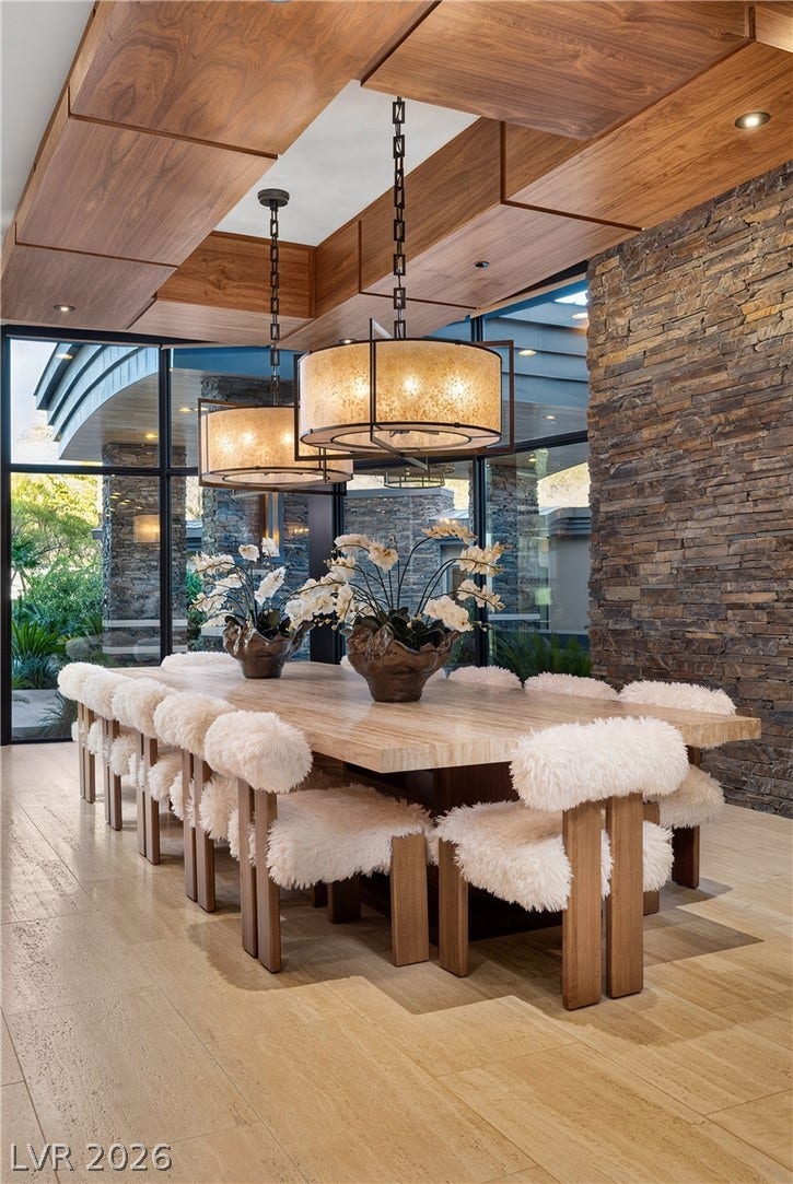 761 Dragon Ridge Drive, Henderson, NV 89012 A stone accent wall and natural wood ceiling details frame this elegant dining space.