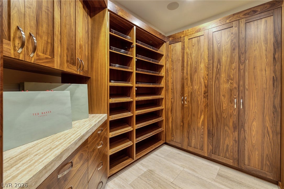 761 Dragon Ridge Drive, Henderson, NV 89012 Rich wood cabinetry and stone counters define this master closet space.