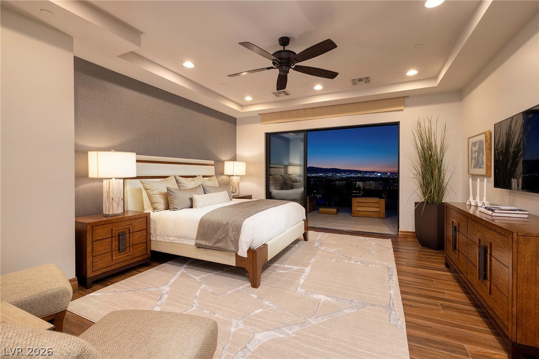 761 Dragon Ridge Drive, Henderson, NV 89012 Rich wood floors and a recessed ceiling frame glass doors opening to city views.
