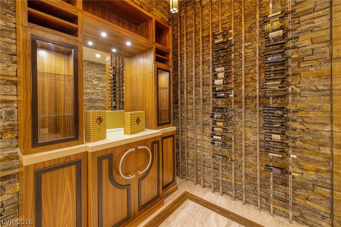761 Dragon Ridge Drive, Henderson, NV 89012 Rich wood cabinetry and stacked stone walls define this elegant, temperature-controlled wine room.