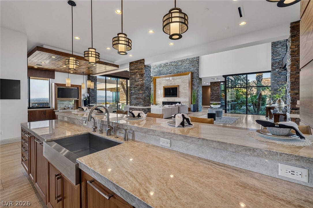 761 Dragon Ridge Drive, Henderson, NV 89012 Premium stone countertops highlight the expansive island overlooking the grand main living space.