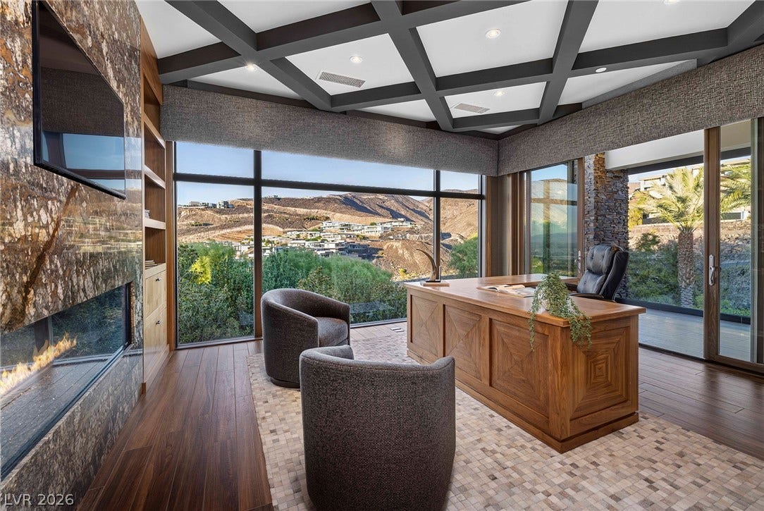 761 Dragon Ridge Drive, Henderson, NV 89012 A magnificent coffered ceiling and a stone fireplace anchor this impressive home office.