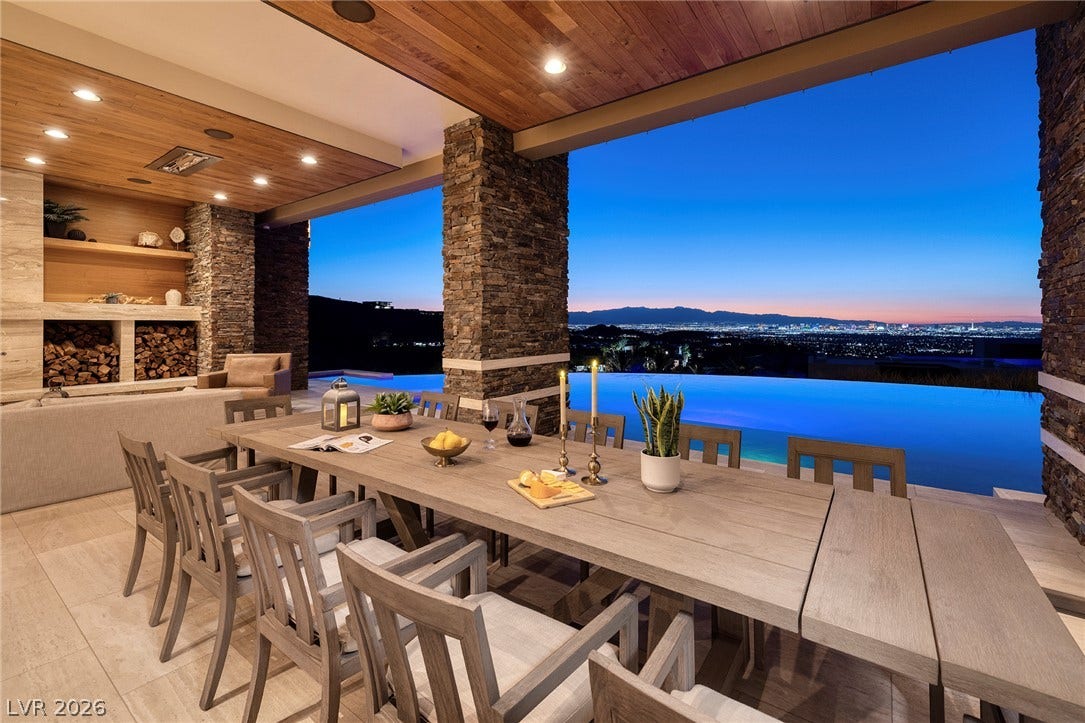 761 Dragon Ridge Drive, Henderson, NV 89012 An outdoor dining area overlooks a sparkling infinity pool and distant city lights at sunset.