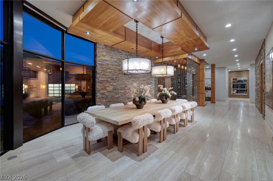 761 Dragon Ridge Drive, Henderson, NV 89012 Floor-to-ceiling glass doors and rustic stone accents frame an elegant formal dining space.