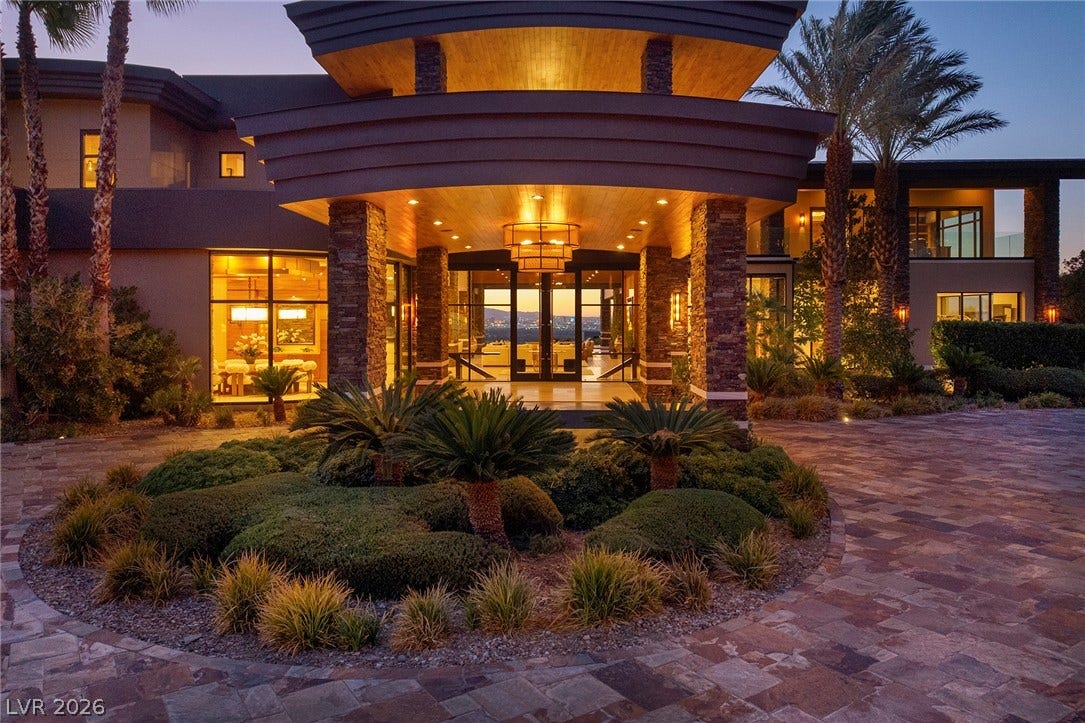 761 Dragon Ridge Drive, Henderson, NV 89012 Dramatic stone pillars flank a covered grand entry overlooking a sweeping paved courtyard.