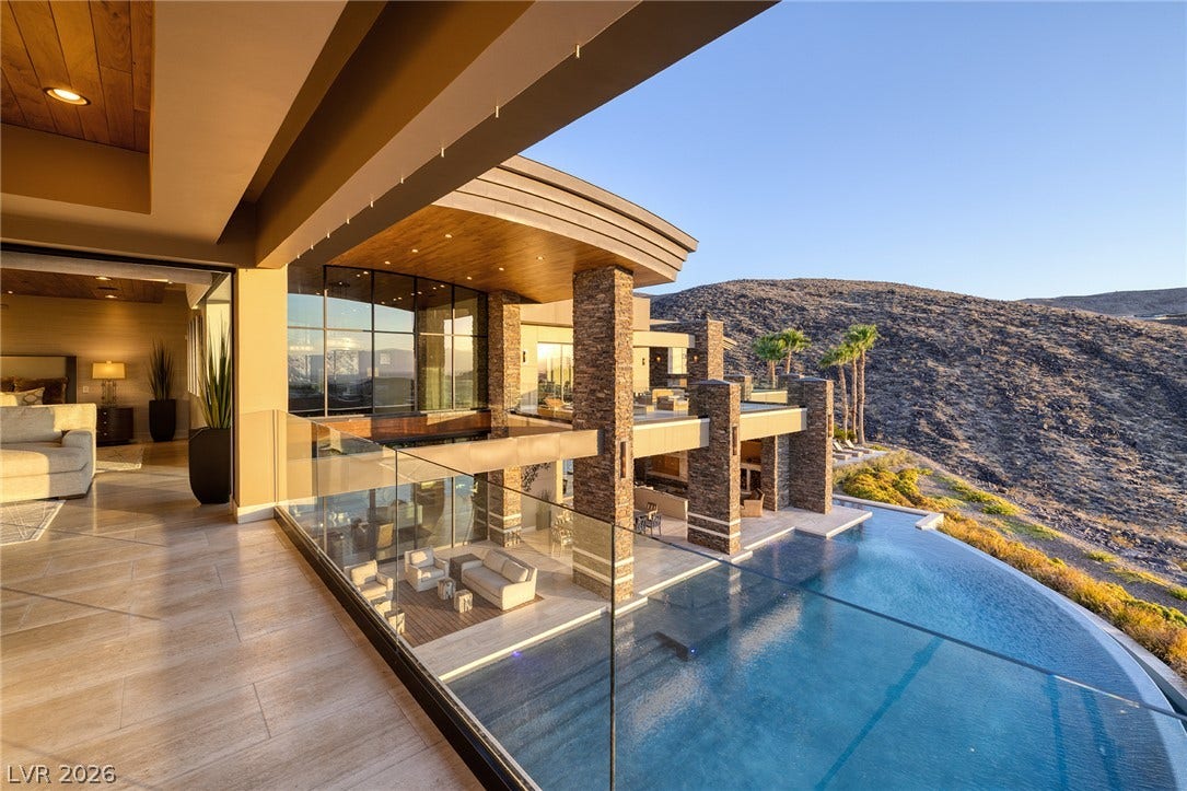 761 Dragon Ridge Drive, Henderson, NV 89012 Dramatic modern architecture seamlessly integrates a sleek infinity pool with sweeping desert hillside views.