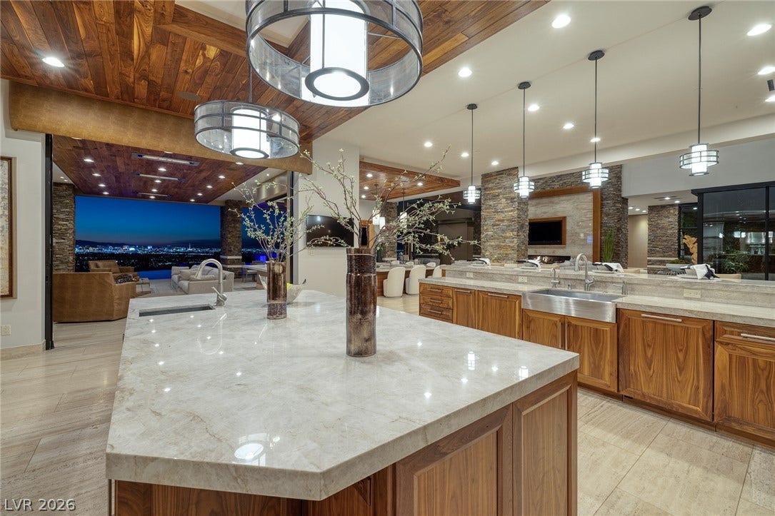 761 Dragon Ridge Drive, Henderson, NV 89012 Rich wood ceilings and polished stone counters frame this open-concept culinary space.