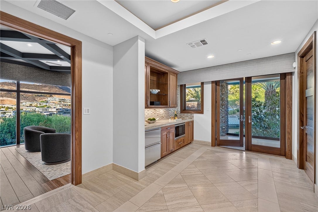 761 Dragon Ridge Drive, Henderson, NV 89012 Gleaming tile floors and a built-in wet bar define this versatile transitional space.