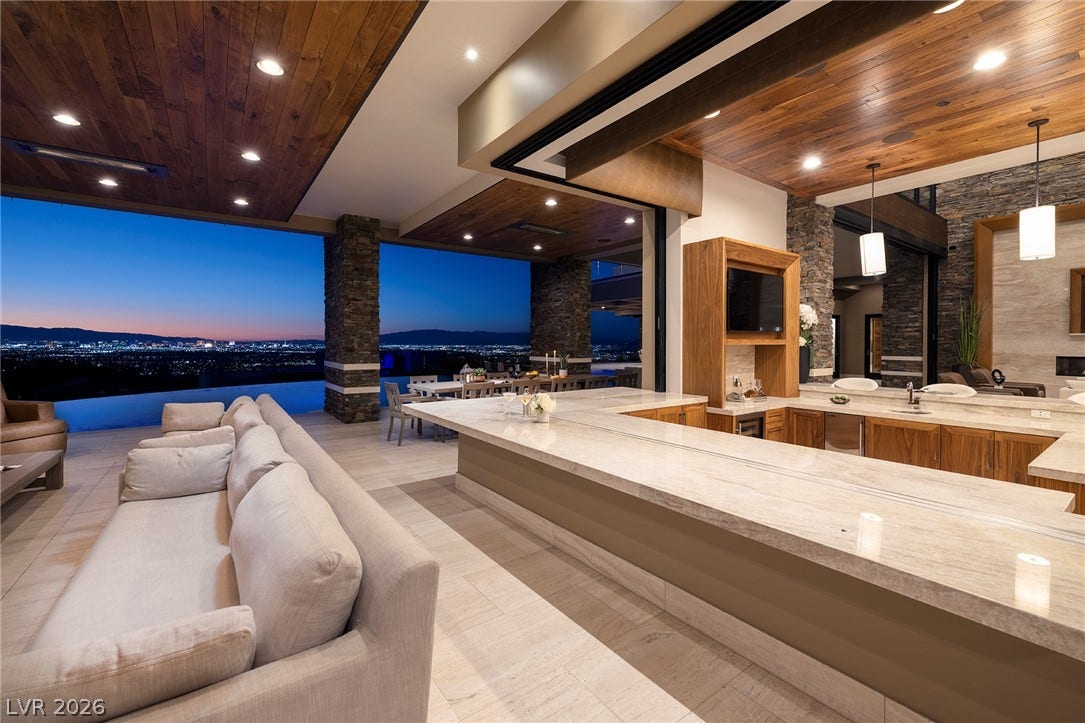 761 Dragon Ridge Drive, Henderson, NV 89012 Rich wood ceilings and stone pillars frame a grand terrace with sweeping city views.