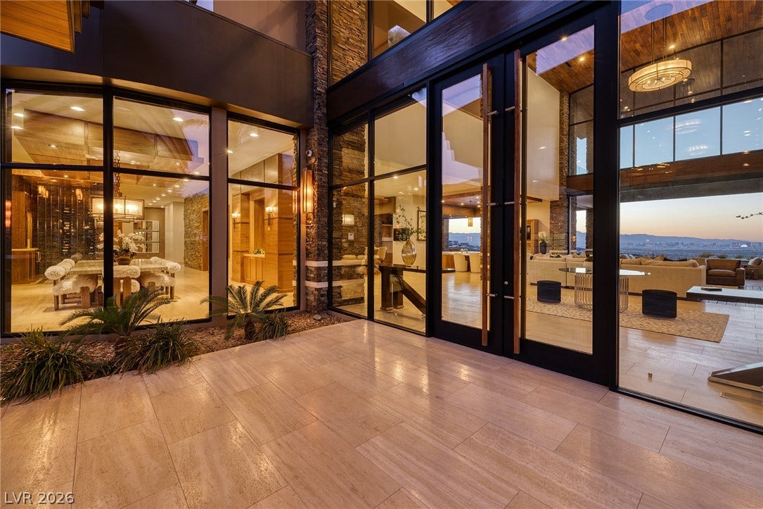 761 Dragon Ridge Drive, Henderson, NV 89012 Towering glass walls seamlessly connect the tiled terrace to the dramatic, open-concept interior spaces.