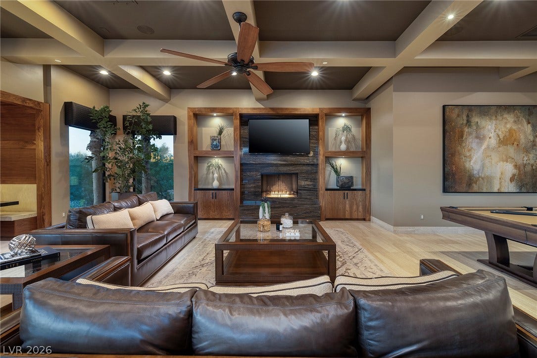 761 Dragon Ridge Drive, Henderson, NV 89012 An elegant stone fireplace anchors this living space beneath a dramatic coffered ceiling.