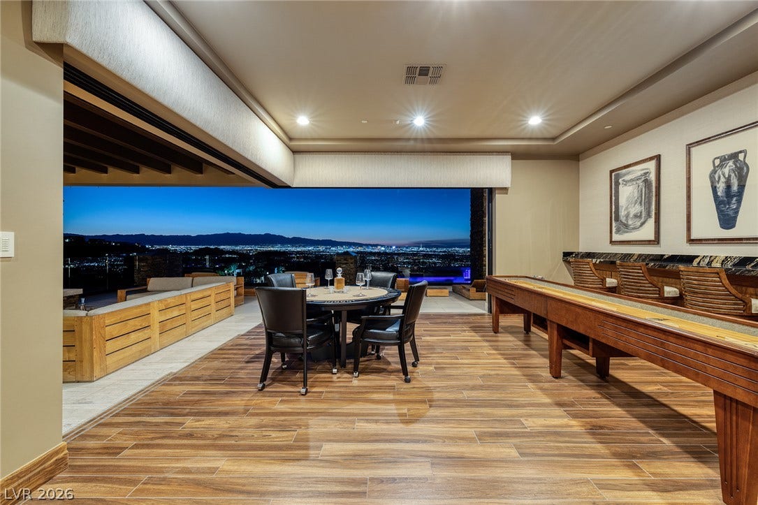 761 Dragon Ridge Drive, Henderson, NV 89012 Retracting glass walls merge the indoor recreation room with sweeping city light views.