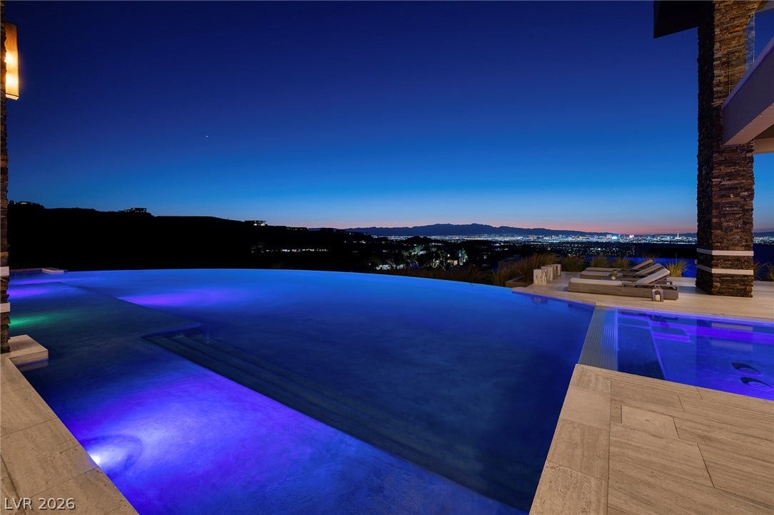 761 Dragon Ridge Drive, Henderson, NV 89012 An illuminated infinity pool frames sweeping vistas of the glittering city lights below.