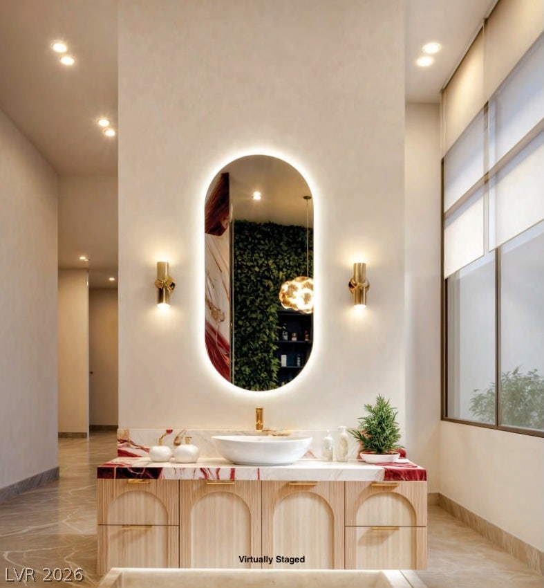 "Virtually Staged" Recessed lighting illuminates this elegant space showcasing a marble-topped vanity and stone tile flooring.